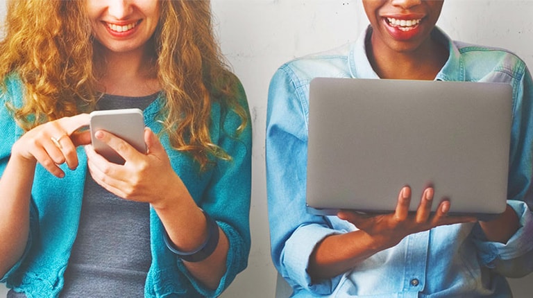 Women looking at phone and laptop