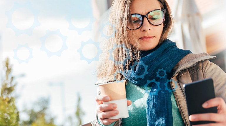 Woman Drinking Coffee Looking at Smartphone