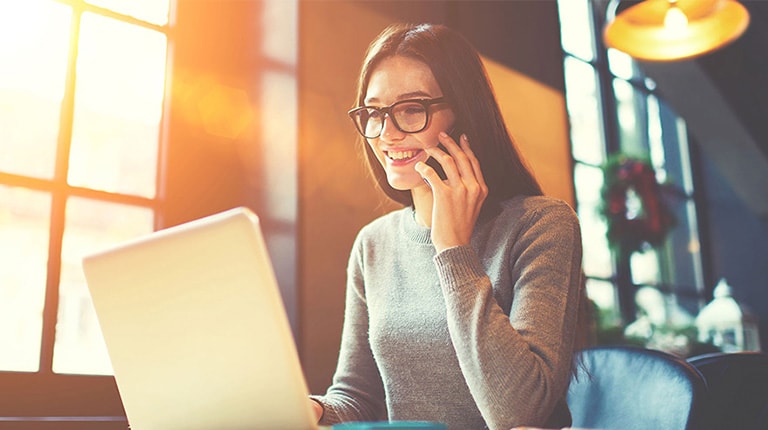 Woman on phone looking at computer