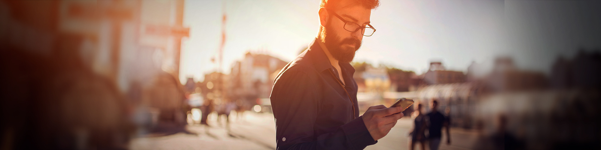 Man with glasses looking at phone