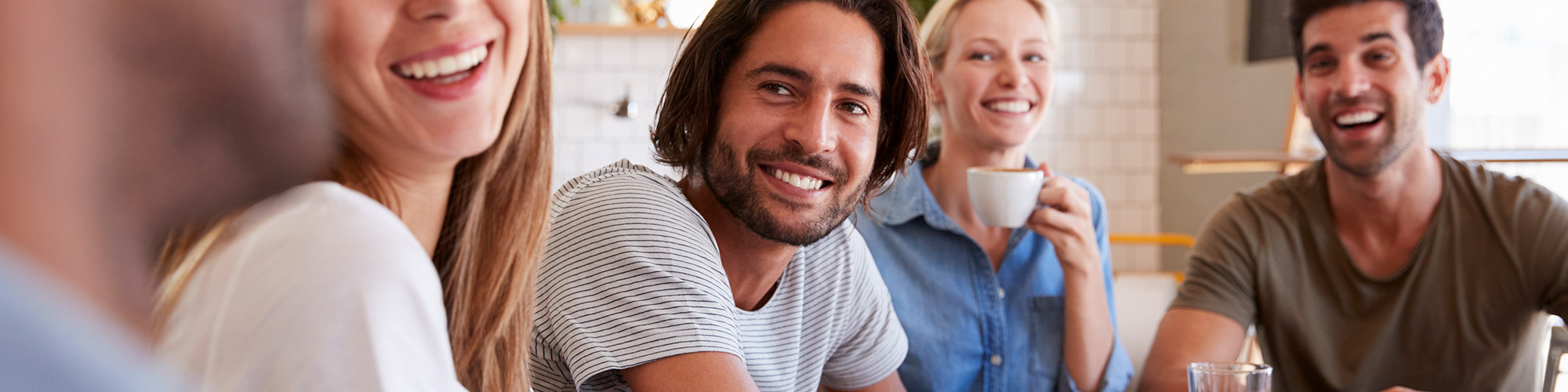 Group of people laughing and drinking coffee